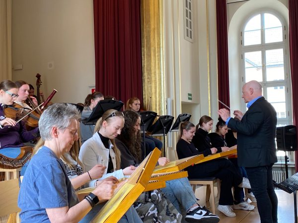 Das Projektschulorchester mit der Zauberharfensektion im Vordergrund und dem Dirigenten