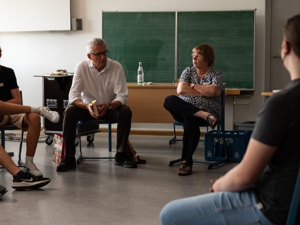 Dr. Thomas Sparr spricht im Kreis mit Schülerinnen und Schülern